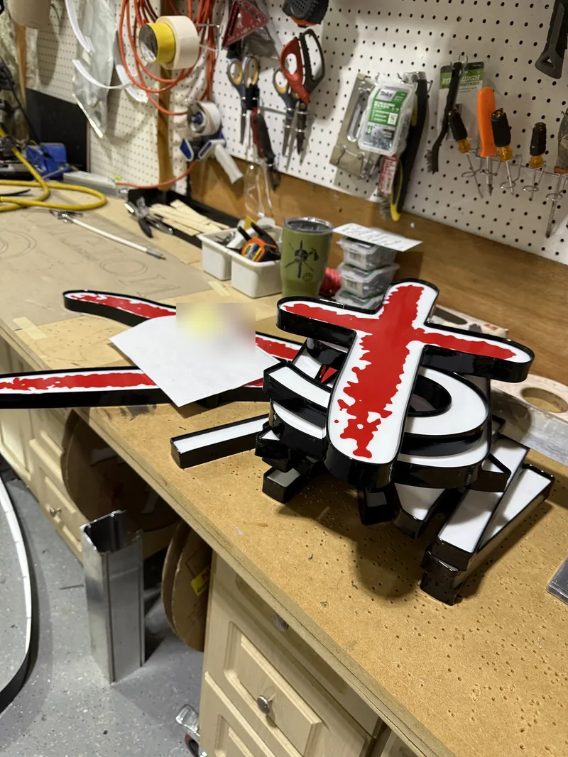 Mathnasium letters and red plus logo face being built on the Quality Signs shop bench
